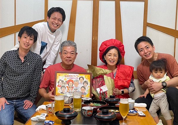 似顔絵を持って家族集合写真